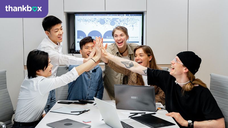 Team high fives across a desk