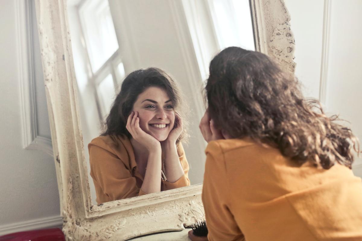 Woman looking into the mirror and smiling
