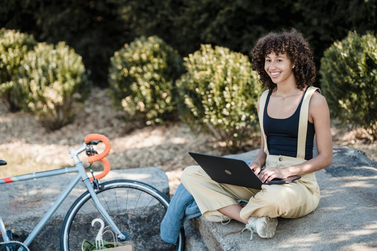 Cheerful female using laptop outdoors