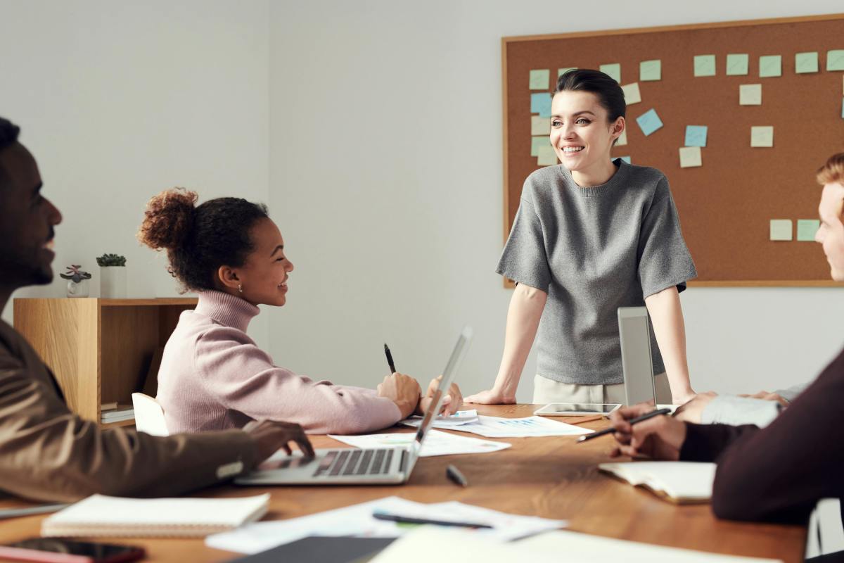 A businesswoman in a grey shirt talking with her colleagues