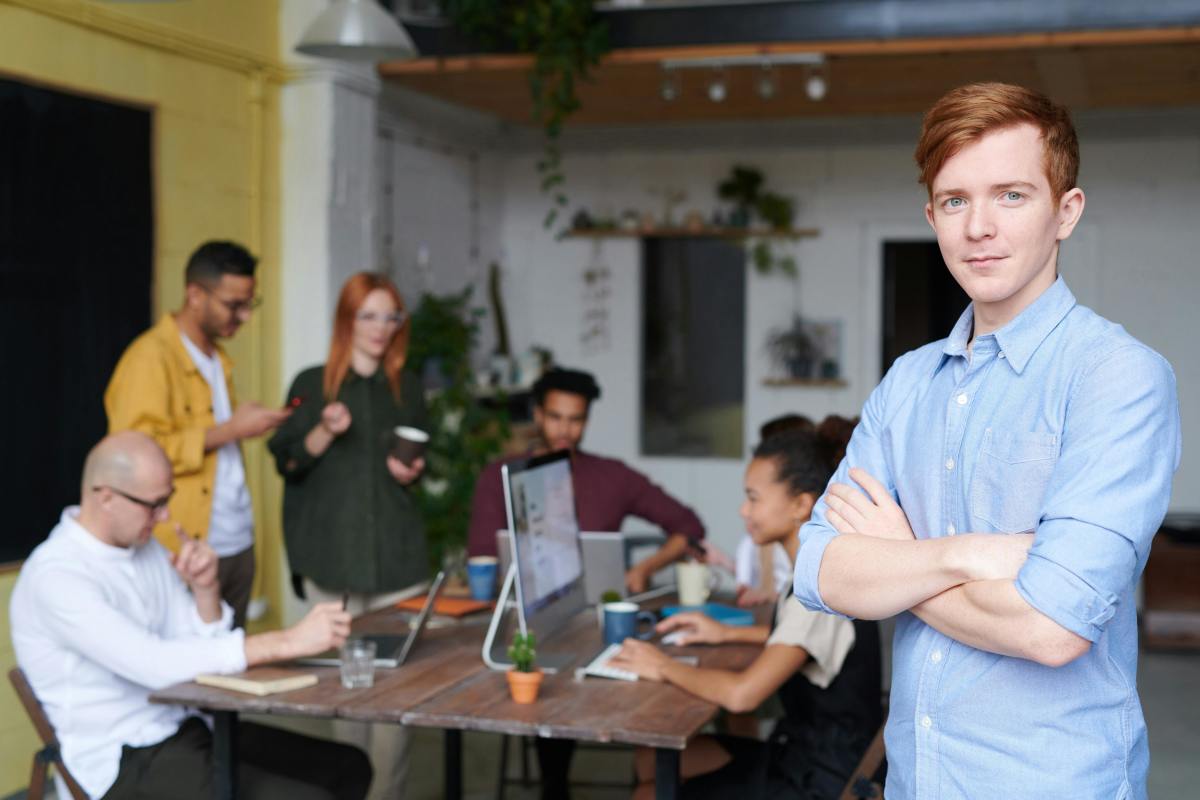Man standing beside his team in the office