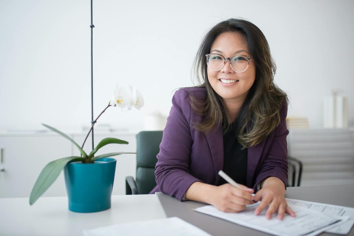 Woman sitting on a table and filling out papers