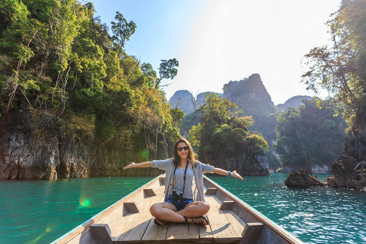 Woman sitting on a boat spreading her arms