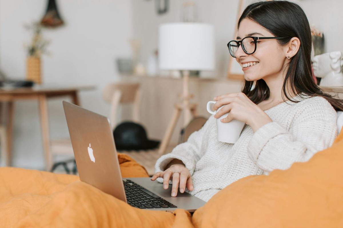 Woman having coffee while using a laptop