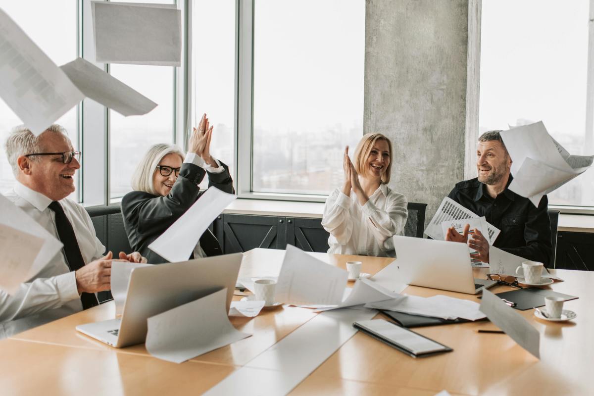 Coworkers throwing paper sheets in the office