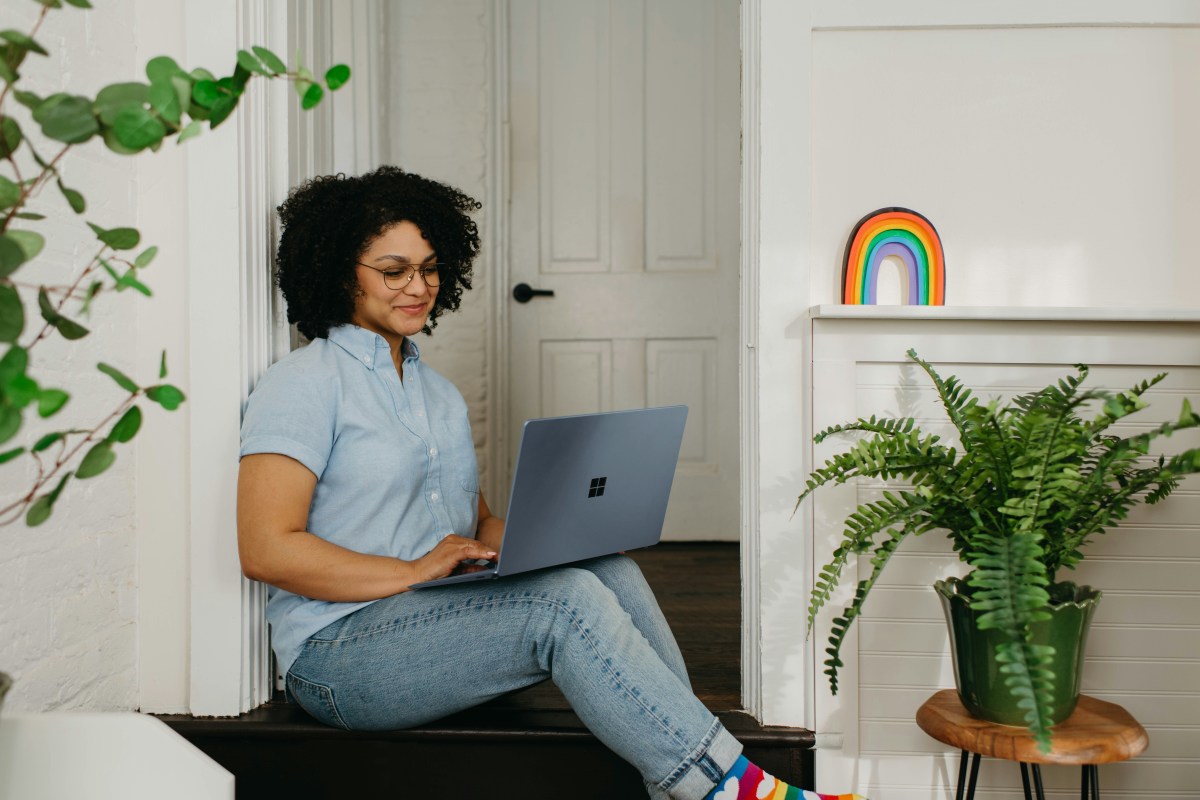 A woman sitting on the floor and using a laptop